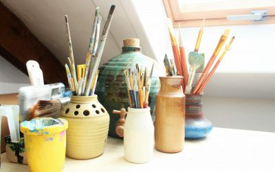 Pinsel und Farbe in Vasen